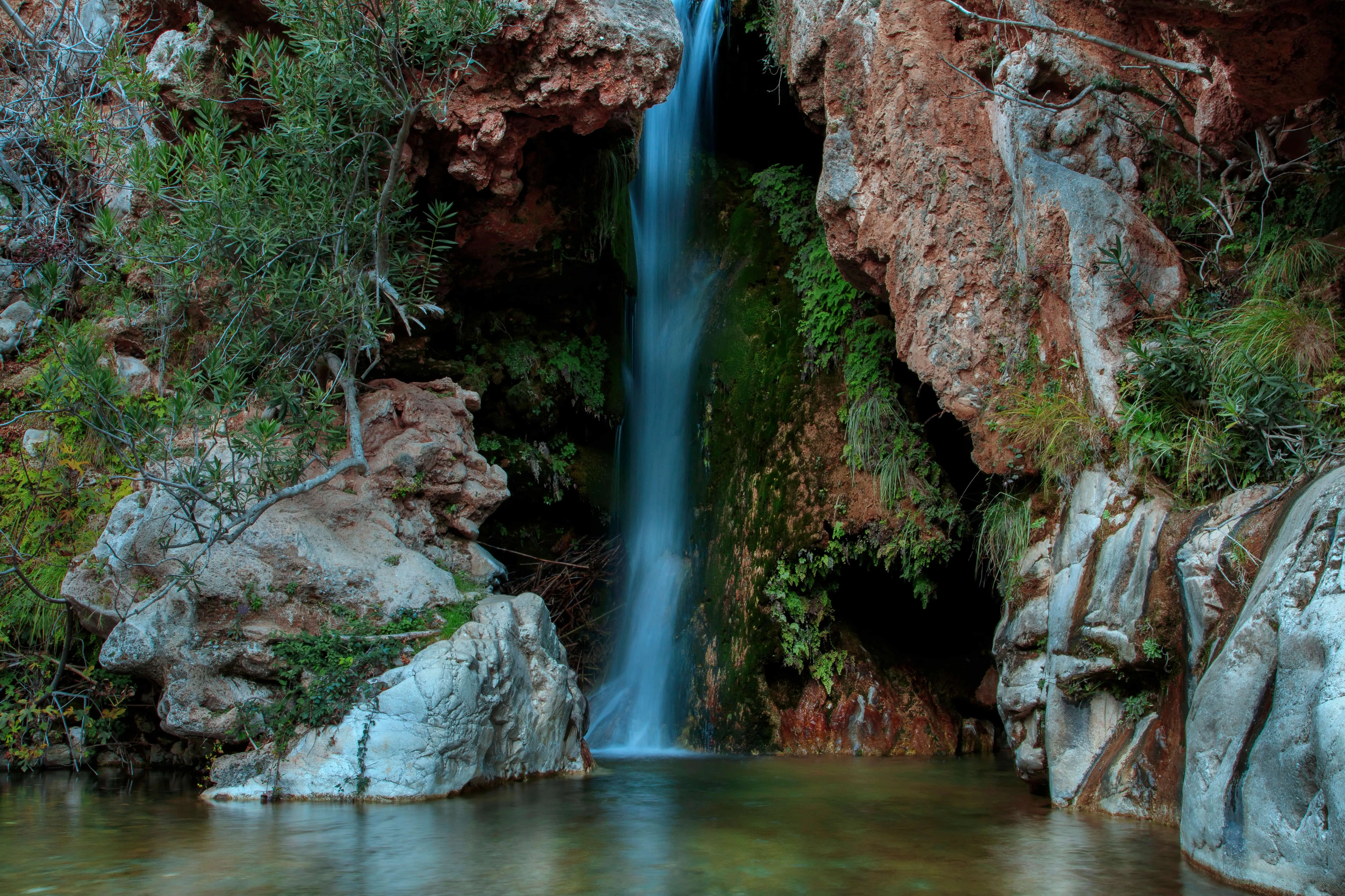 A waterfall tumbling into a natural rock pool at Barranco Blanco